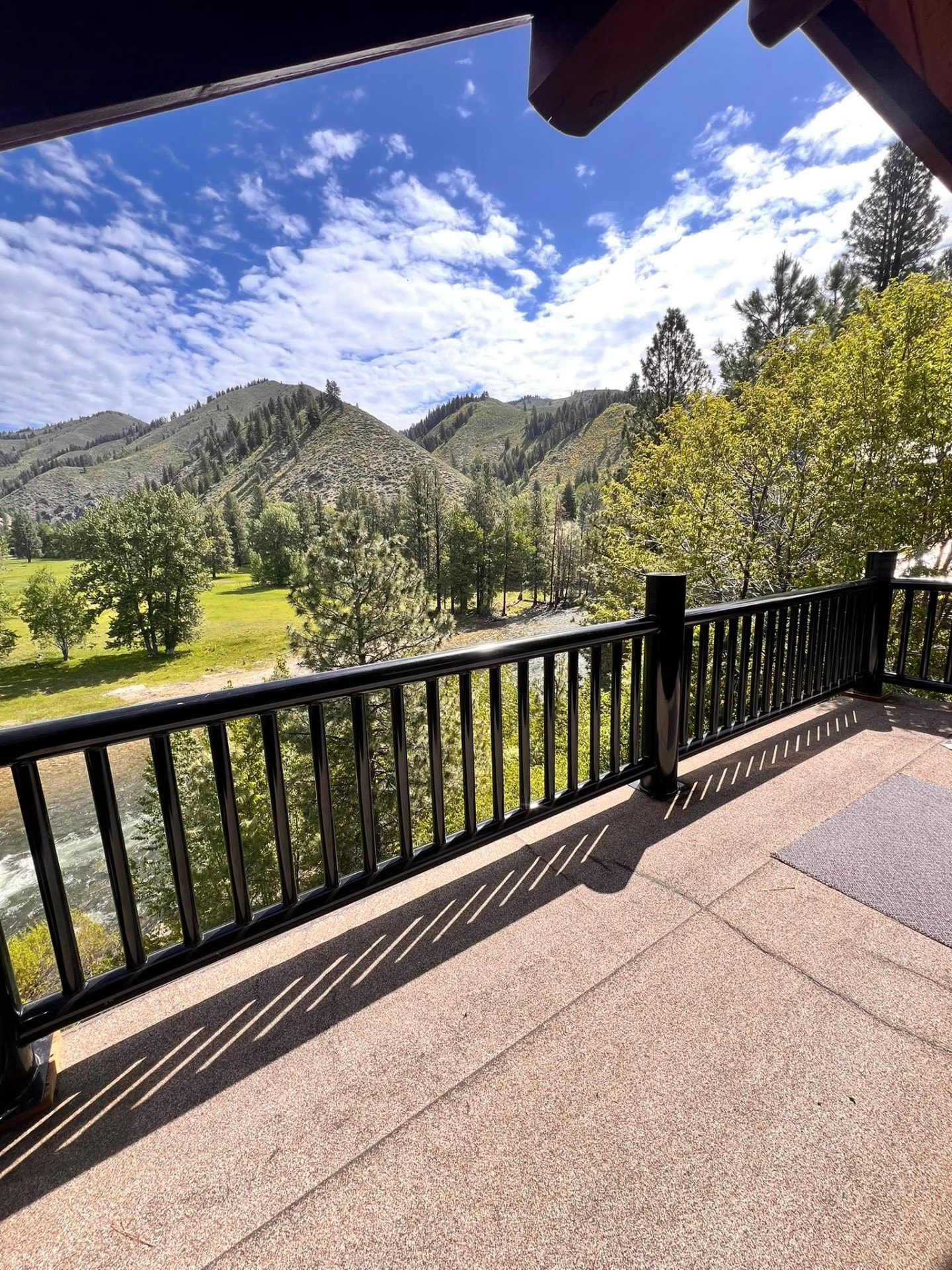 Black steel deck railing with vertical balusters overlooking a river and mountains in Idaho