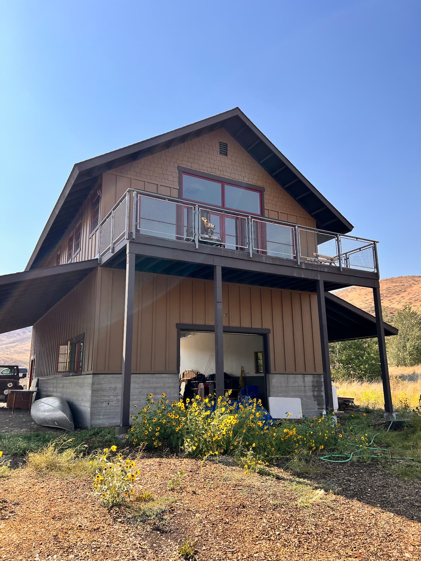 Elevated residential balcony with custom steel railing and support columns on a mountain property