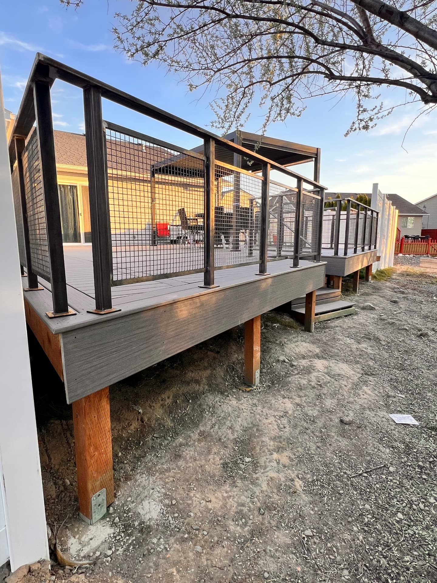 Welded steel mesh guardrail wrapping a raised composite deck at a residential property